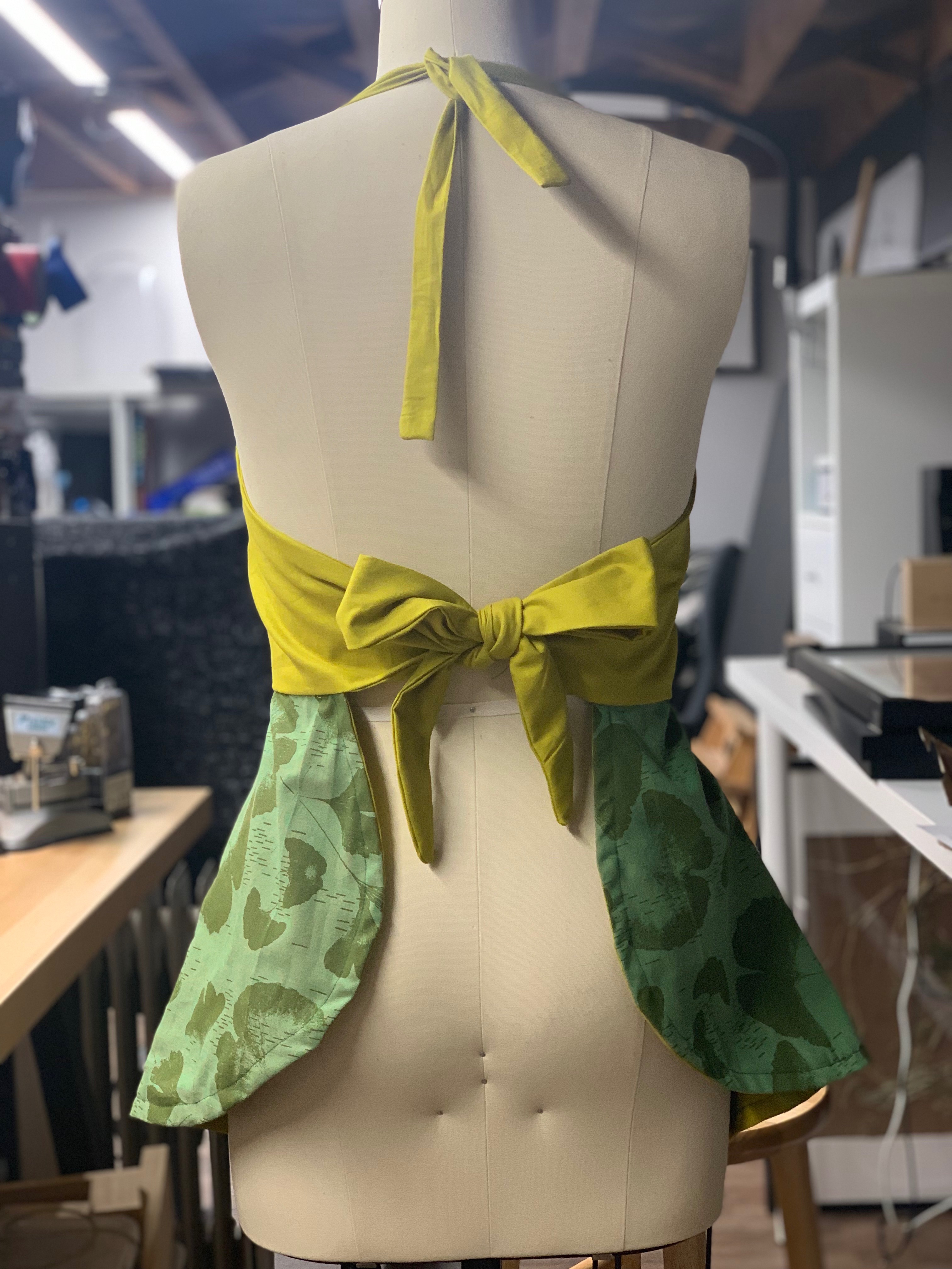 A side view of the apron, featuring a ginkgo leaf motif in shades of green