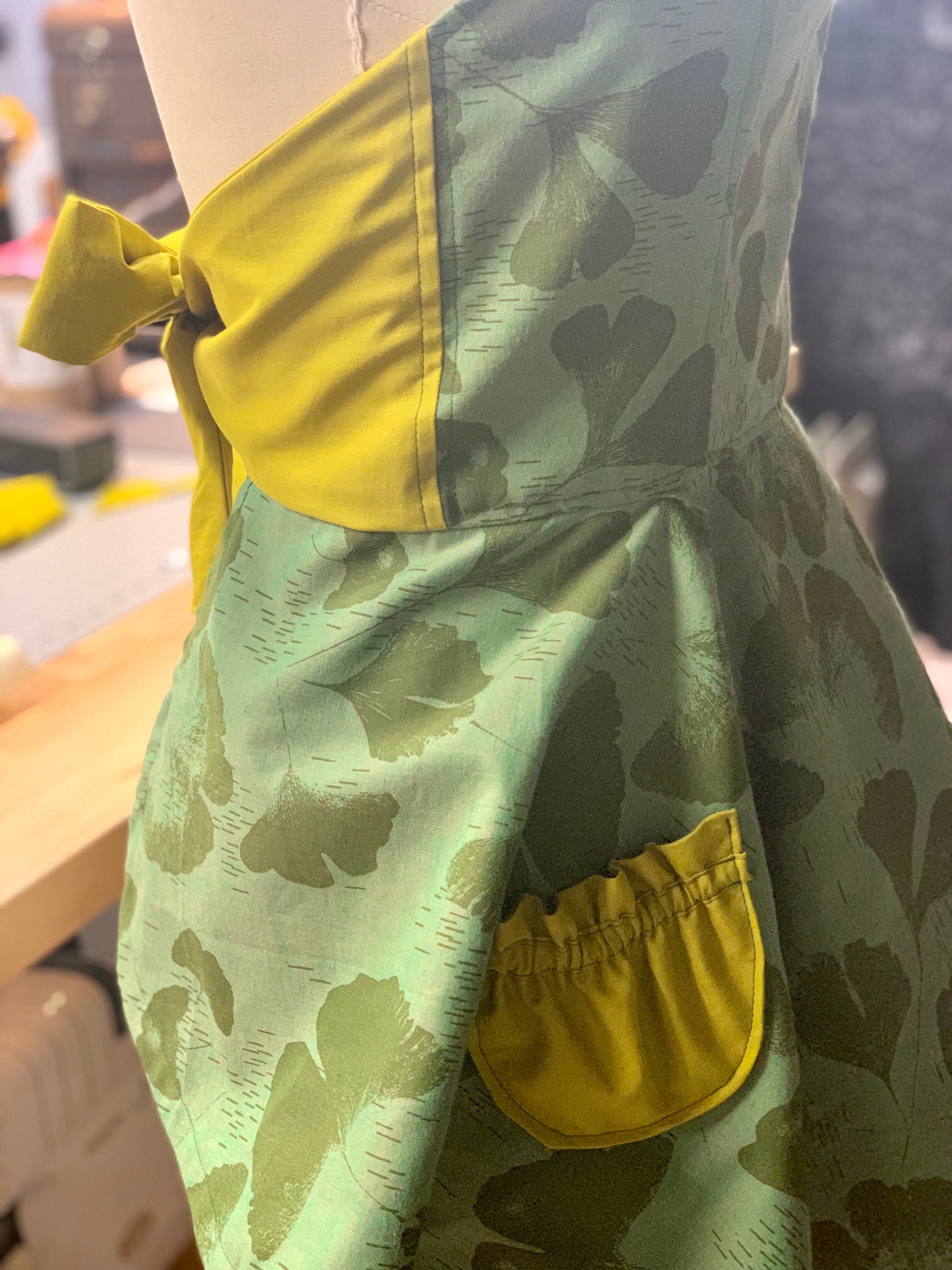 A rear view of the apron, featuring a ginkgo leaf motif in shades of green
